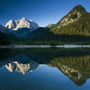 Mount Prisojnik (2, 547m) and Mount Razor (2, 601m) with reflection in a lake beside Mount Prisojnik (2, 547m) and Mount Razor (2, 601m) with reflection in a lake beside