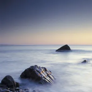 Pebbles and surf on beach at dusk, Sandymouth bay, Cornwall, UK