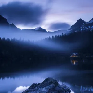 Popradske Pleso, looking toward mountain range, in late evening light, with reflections and mist