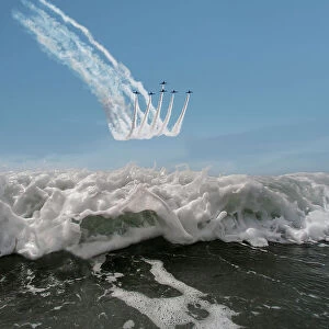 The Red Arrows display team flying in formation over the sea, Rhosneigr, Anglesey, Wales, UK. August, 2022