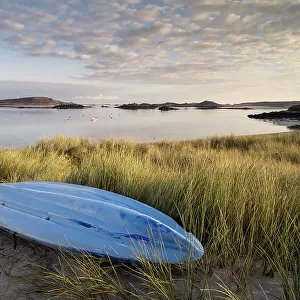 RF - Kayak and sand dunes bathed in early morning light, overlooking bay, Tresco, Isles of Scilly, Cornwall, UK. September. (This image may be licensed either as rights managed or royalty free)