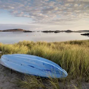 RF - Kayak and sand dunes bathed in early morning light, overlooking bay, Tresco, Isles of Scilly, Cornwall, UK. September. (This image may be licensed either as rights managed or royalty free) RF - Kayak and sand dunes bathed in early morning light, overlooking bay, Tresco, Isles of Scilly, Cornwall, UK. September. (This image may be licensed either as rights managed or royalty free)