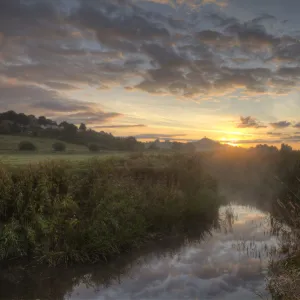 River Brue, at dawn with Glastonbury Tor in background, Somerset, UK, August