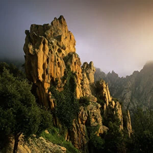 Rock formations in the fog at sunset, in the Calanche of Piana, Gulf of Porto UNESCO