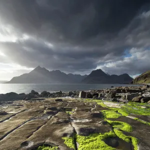 Rocky shoreline, Loch Scavaig and view to Cuillin mountians, Isle of Skye, Scotland, UK, April