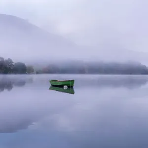 Rowing boat on Ullswater in early morning mist, Lake District, Cumbria, England, UK. November 2015 Rowing boat on Ullswater in early morning mist, Lake District, Cumbria, England, UK. November 2015