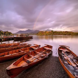 Rowing boats and jetties along the shore of Derwentwater, morning light and rainbow, Keswick, Cumbria, The Lake District, UK. October 2019 Rowing boats and jetties along the shore of Derwentwater, morning light and rainbow, Keswick, Cumbria, The Lake District, UK. October 2019
