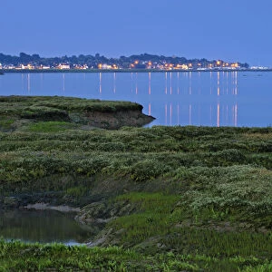 Saltmarsh at twilight, with lights of Bradwell-on-Sea in the background, Abbotts