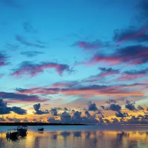 The sky lights up at dawn with boats floating on still waters off the island of Yap, Micronesia, Pacific Ocean The sky lights up at dawn with boats floating on still waters off the island of Yap, Micronesia, Pacific Ocean
