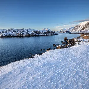 Snow over shore and mountains in winter, Henningvaer, Lofoten Islands, Norway. March, 2023 Snow over shore and mountains in winter, Henningvaer, Lofoten Islands, Norway. March, 2023