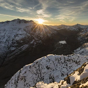 Sunset over snow covered mountains, view north west along Aonach Eagach ridge towards Glen Coe