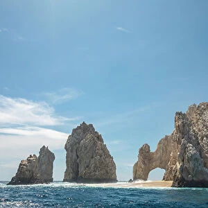 Tourist boat passing the arch of Cabo San Lucas, a distinctive granitic rock formation at the southern tip of Cabo San Lucas, Baja California, Mexico, Pacific Ocean. October, 2018