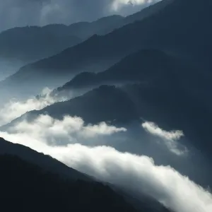 Upcoming clouds over forest covered mountains Upcoming clouds over forest covered mountains