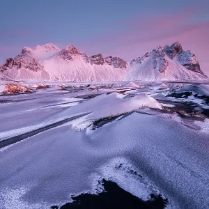 Vestrahorn mountain and sand dunes covered in snow at sunrise. Stokksnes Peninsula, Iceland. January, 2024