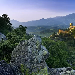 The village of Eus perched on a hilltop with sunlight with the Pic de Canigou beyond