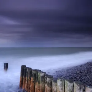 Weathered groyne, pebbles and stormy evening sky at Bossington beach, Exmoor National Park Weathered groyne, pebbles and stormy evening sky at Bossington beach, Exmoor National Park