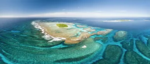 Aerial panorama of Maninita Island which sits atop an extensive coral reef structure, which is for the most part not visible from the surface of the ocean. Visible to the right behind Maninita is Taula Island