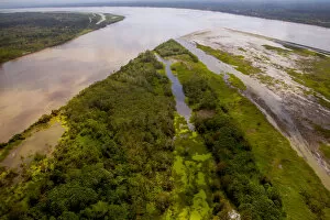 Aerial view of Amazon River, with settlements and secondary rainforest, near Iquitos, Peru