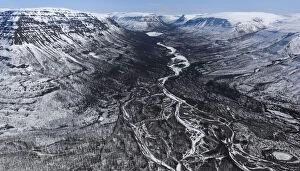 Aerial view of braided river running through valley on snow covered plateau, Putoransky State Nature Reserve