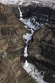 Aerial view of frozen waterfalls in deep canyon in plateau, Putoransky State Nature Reserve, Putorana Plateau, Siberia