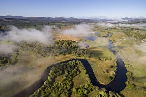 Aerial view of low cloud over the River Spey meandering through Insh marshes, Cairngorms National Park, Scotland, UK