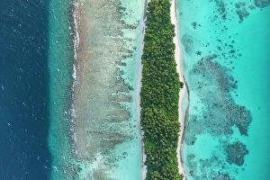 Cool Coloured Coasts Collection: Aerial view of narrow coral atoll island with palm trees and white sand beach surrounded by reef