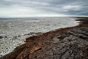 Aerial View Prints: Aerial view of the rocky shoreline of the Hudson Bay with sea ice starting to break up as spring warms the land and sea
