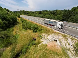 Road Prints: Aerial view of a wildlife underpass below the A89 highway with truck driving by above