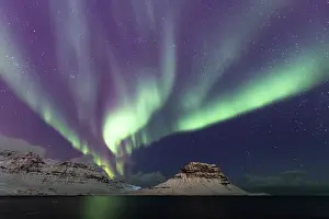 Natural Light Prints: Aurora borealis lighting up the night sky over snow-covered mountains