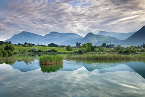 Range Prints: The Bauges Mountains reflected in St Andre lake at dawn, Haute-Savoie, France. June, 2022