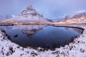 Buachaille Etive Beag reflected in Lochan na Fola after snowfall, early morning light