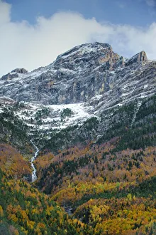 Bujaruelo Valley with stream and waterfall and snow above the tree line; mixed deciduous