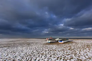 Cley Beach with scattering of light snow, and boats, Norfolk, England, UK, December 2010