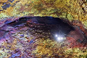 Travel Prints: Colourful rocks inside the magma chamber of Thrihnukagigur volcano with torch light from an open cable lift