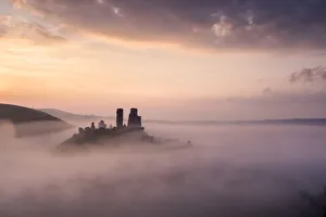 Corfe castle and village at dawn with mist, Corfe Castle, The Purbecks, Dorset, UK