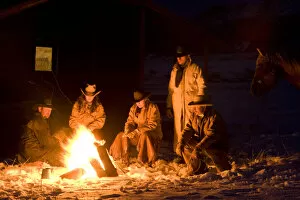 2009 Highlights Collection: Cowboys sitting round camp fire, Flitner Ranch, Shell, Wyoming, USA Model released