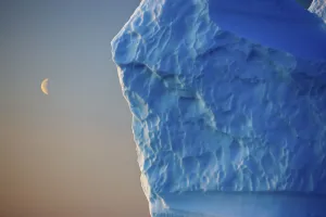 Icebergs Gallery: Edge of iceberg with the moon in the sky, Greenland, August 2009