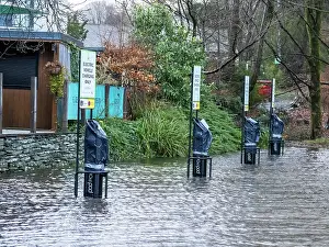 Lake District Prints: Electric car charging points submerged in water in a flooded carpark after heavy rain