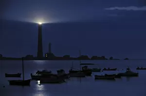 Fishing boats and lighthouse at night on the island Ile Vierge, Brittany, France