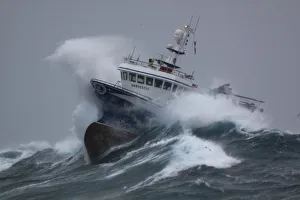 Fishing vessel Harvester powering through huge waves while operating in the North Sea