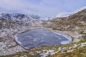 Mountain Gallery: Frozen Llyn Teyrn with Y Llewydd and Mount Snowdon in background. View west from Miners Track