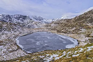 Frozen Llyn Teyrn with Y Llewydd and Mount Snowdon in background. View west from Miners Track
