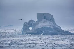 Sue Flood Gallery: Helicopter from Russian icebreaker Kapitan Khlebnikov flies past iceberg in the Weddell