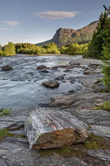 The Hemsila river in summer, tree-lined riverbanks and hills with high cloud in sky, Hemsedal region, Norway. June, 2022