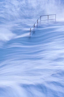 High tide and metal hand railings at Bude Sea Pool, Bude, North Cornwall, UK. May 2021