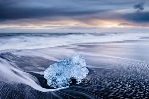 Gloomy Prints: Ice on black volcanic sand beach with waves, Jokulsarlon, Southeast Iceland, February