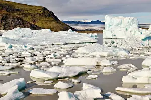 Iceberg Prints: Ice floating on glacial lagoon with glacier in background