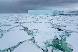 Iceberg Prints: Iceberg amongst sea ice under dark sky