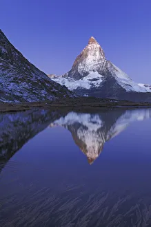 Snowcapped Prints: Matterhorn at sunrise in autumn with reflection in the Riffelsee. Zermatt, Valais