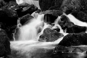 Time Exposure Prints: Monochrome image of waterfall breaking on rocks at the base of Lodore Falls